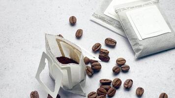 Drip coffee paper bags with coffee beans on a grey concrete background video