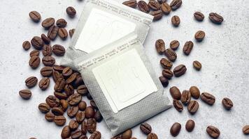 Drip coffee paper bags with coffee beans on a grey concrete background video