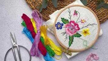 The process of hand embroidering a napkin with colored threads on white fabric. video