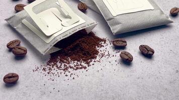 Drip coffee paper bags with coffee beans on a grey concrete background video