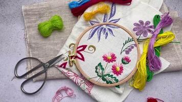 The process of hand embroidering a napkin with colored threads on white fabric. video