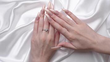 Manicured nails with pearlescent nail polish.  The nails are covered with pearl gel polish on white background video