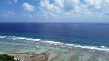 Drohne Aussicht von Paradies Inseln von das Malediven mit Koralle Riffe unter das Wellen von das indisch Ozean. video