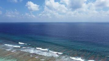 drone vue de paradis îles de le Maldives avec corail récifs en dessous de le vagues de le Indien océan. video