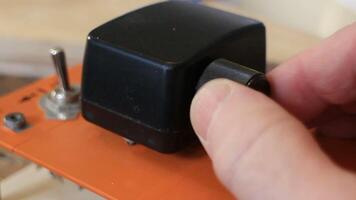 man turns a round toggle switch for control bullets close up video