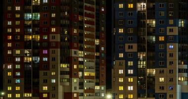 natt tid upphöra med ljus i fönster av flervånings- byggnader. liv i en stor stad. serenad av ljus video