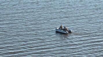 caçadores furtivos pescadores vela em uma borracha barco em a lago dentro procurar do peixe video