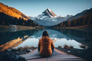 AI generated The girl sits and looks at the mountains and lake alone. Generated by artificial intelligence photo