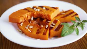 hot with steam sweet baked grilled pumpkin with seeds in a plate video