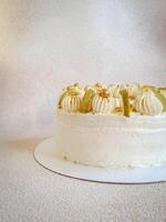 White cake with white cream and slices of pear, side view photo