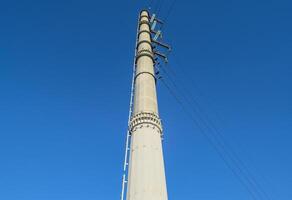 Supports high-voltage power lines against the blue sky photo