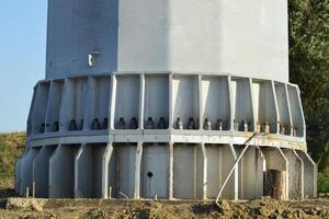 The base of the column power line support. Massive metal pole photo