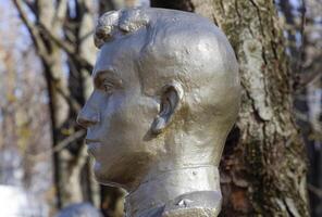 The face of the stone man. Concrete soldier bust covered with pa photo