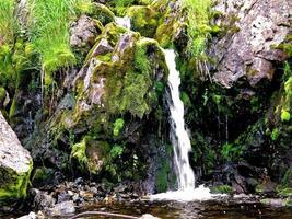 Waterfall from the thawed waters. Melting snow in the hilly tund photo