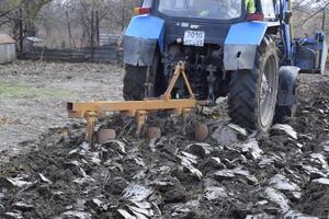 Tractor plowing the garden. Plowing the soil in the garden photo