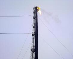 Torch system on an oil field. System of a torch on an oil field. Burning through a torch head. photo