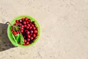 cerezas en un el plastico verde balde. maduro rojo dulce Cereza foto