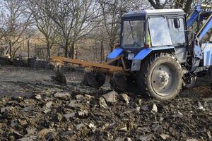 Tractor plowing the garden. Plowing the soil in the garden photo