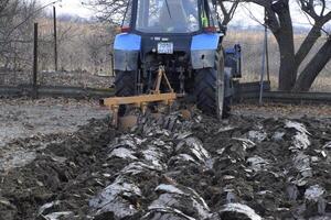 Tractor plowing the garden. Plowing the soil in the garden photo