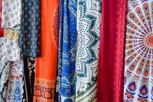 Indian fabrics hanging on the counter. Trade in fabrics from india. Fabric with patterns and patterns photo