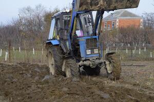 Tractor plowing the garden. Plowing the soil in the garden photo