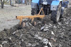 Tractor plowing the garden. Plowing the soil in the garden photo