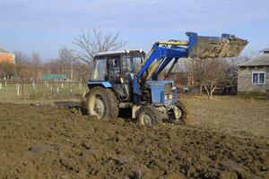 Tractor plowing the garden. Plowing the soil in the garden photo