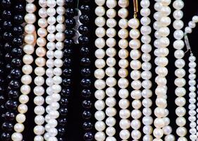 White and black pearls on a black background photo