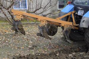 Tractor plowing the garden. Plowing the soil in the garden photo