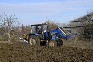 Tractor plowing the garden. Plowing the soil in the garden photo