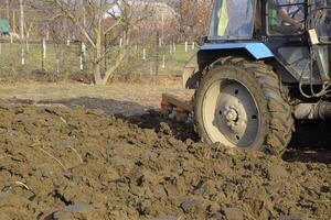 Tractor plowing the garden. Plowing the soil in the garden photo