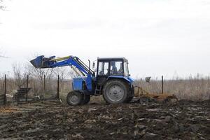 Tractor plowing the garden. Plowing the soil in the garden photo