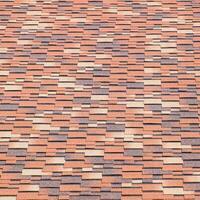 Roof from multi-colored bituminous shingles. Patterned bitumen shingles. photo