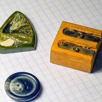 On a sheet of notebook pencil sharpener, a button and a stone amulet photo