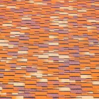 Roof from multi-colored bituminous shingles. Patterned bitumen shingles. photo