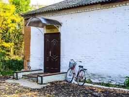 Rural library outside. Bicycle visitor library. The old Soviet building. photo