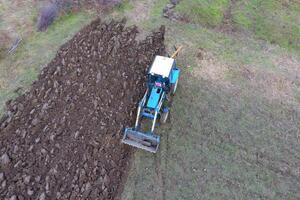 Tractor plowing the garden. Plowing the soil in the garden photo