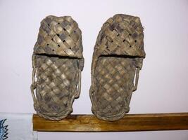 Wicker shoes bast shoes. Bast shoes on a stand. photo