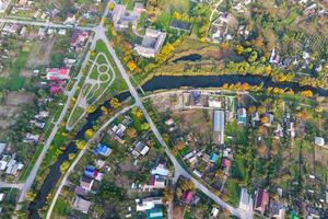 Top view of the village. One can see the roofs of the houses and gardens. Road and water in the village. Village bird's-eye view photo