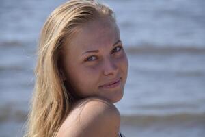 The girl blonde on a background of sea water. Beautiful young woman photo