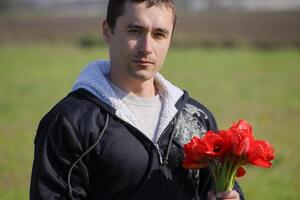 un hombre en un chaqueta en un campo de tulipanes claro con tulipanes foto