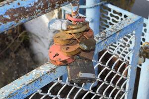 Love locks hung by newlyweds and lovers on the fence near the river. A symbol of strong relationships and eternal love photo