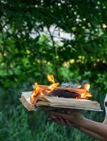 Burning book in the hands. Burning books in the forest. photo