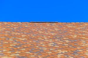 Roof from multi-colored bituminous shingles. Patterned bitumen shingles. photo