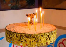 Orthodox church from the inside. Burning wax candles in front of icons and frescoes. Christian religion. photo