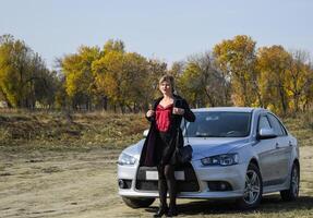 lady in a black cloak in front of a car. Steep ganch style. photo