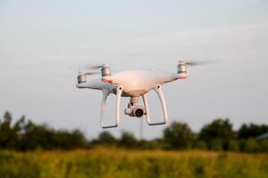 The drone, hovering in the air against the treetops photo