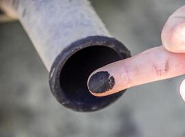 Soot from the exhaust pipe on the finger. Examination of the car's exhaust system by the automaker photo