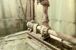 Old rusty pump in the basement. Basement of a water pumping stat photo