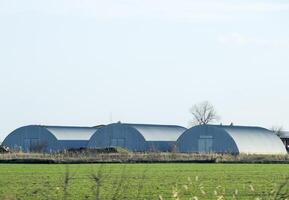 Three hangars in the field. Hangars from galvanized iron. photo